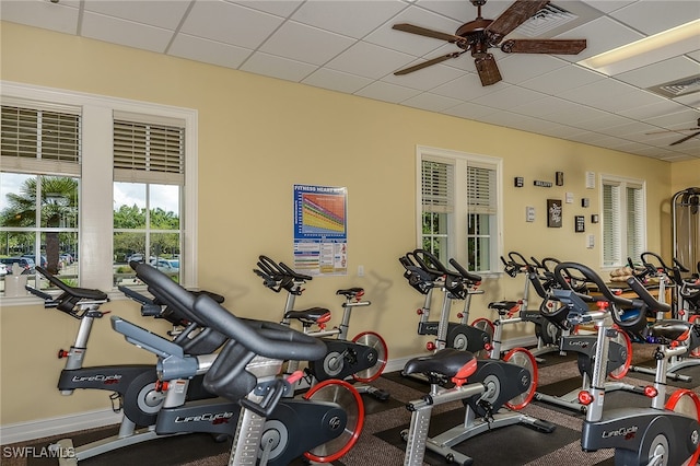 exercise room with ceiling fan and a paneled ceiling