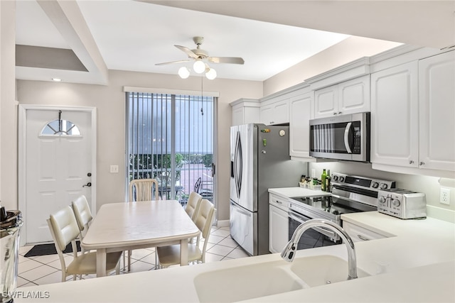 kitchen with stainless steel appliances, ceiling fan, white cabinets, and light tile patterned floors