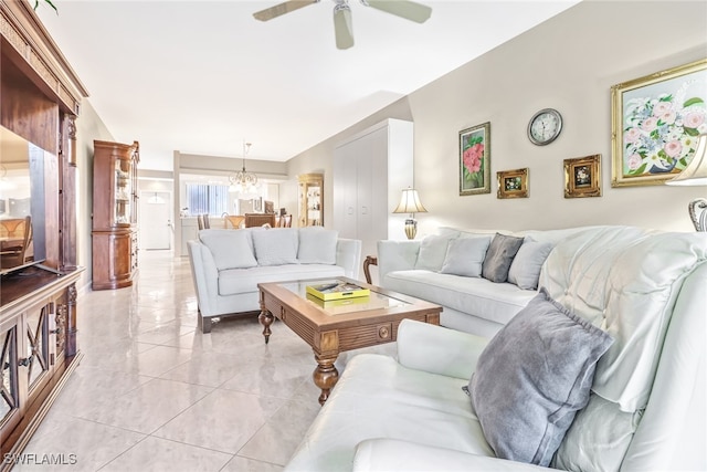 living room featuring ceiling fan with notable chandelier and light tile patterned floors