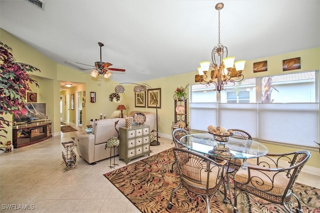 tiled dining room featuring ceiling fan with notable chandelier and lofted ceiling