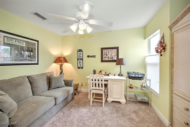 carpeted living room with ceiling fan, baseboards, and an office area