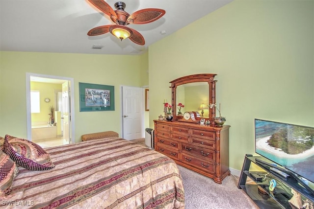 bedroom featuring vaulted ceiling, light carpet, ceiling fan, and ensuite bath