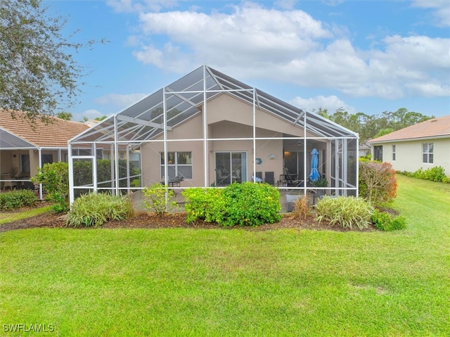 back of house featuring glass enclosure and a lawn