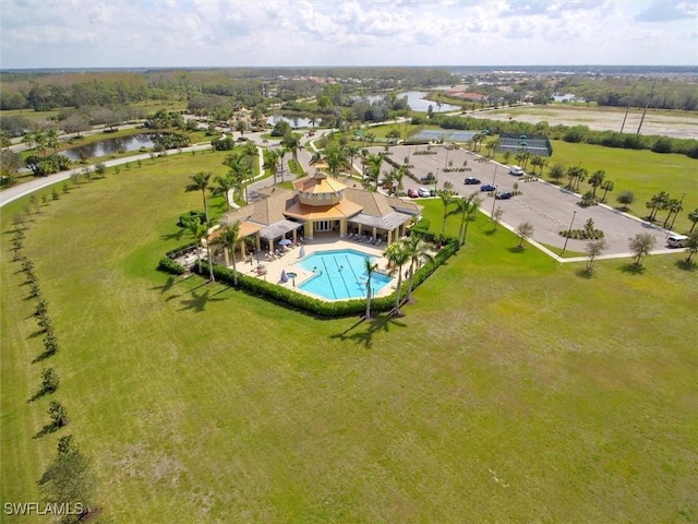 drone / aerial view of a nearby body of water and a pool