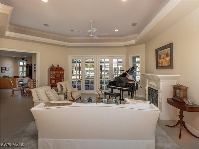 living room featuring french doors, a raised ceiling, ceiling fan, and ornamental molding