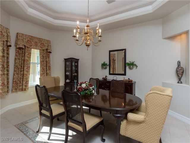 tiled dining room featuring a tray ceiling, ornamental molding, and a notable chandelier