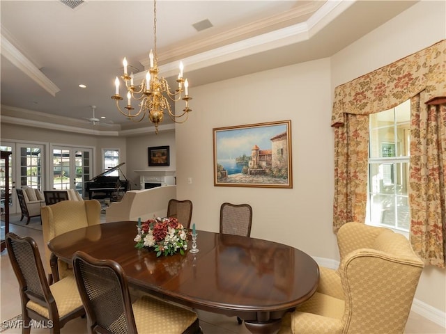 dining space with ceiling fan with notable chandelier, a raised ceiling, and crown molding