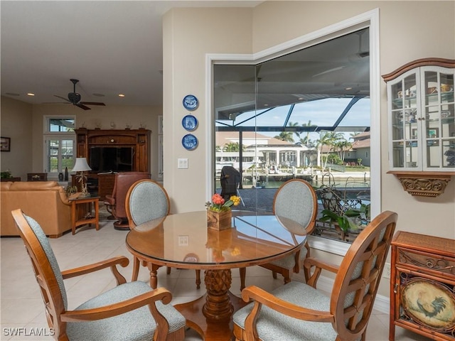 tiled dining space featuring ceiling fan and a healthy amount of sunlight