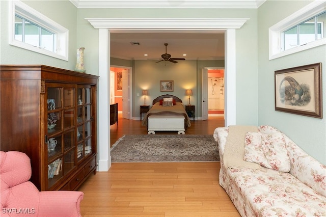 bedroom with light hardwood / wood-style floors, crown molding, and ensuite bath