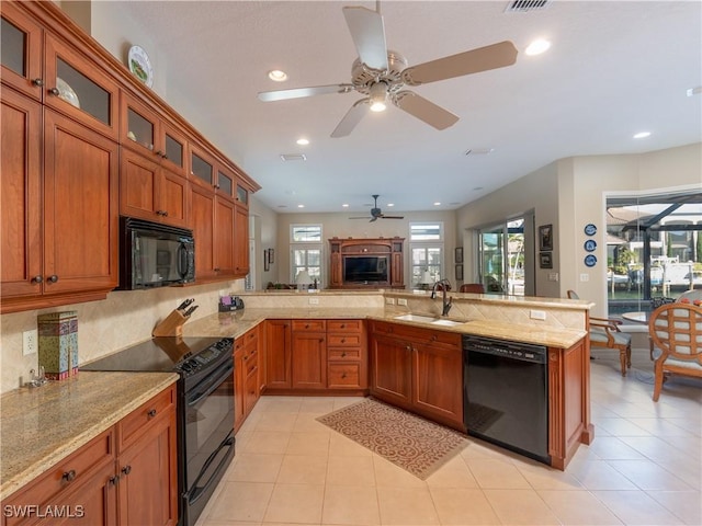 kitchen with black appliances, light tile patterned flooring, kitchen peninsula, and sink