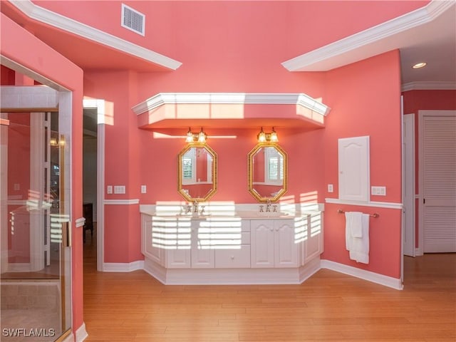 interior space featuring sink, ornamental molding, and light wood-type flooring