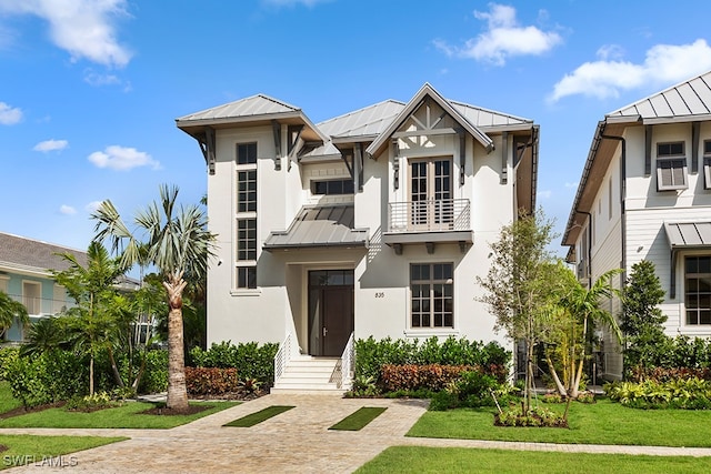 view of front of house with a front lawn and a balcony