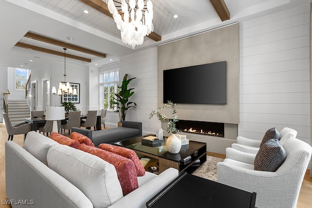 living room featuring wood ceiling, an inviting chandelier, light hardwood / wood-style flooring, beam ceiling, and a large fireplace