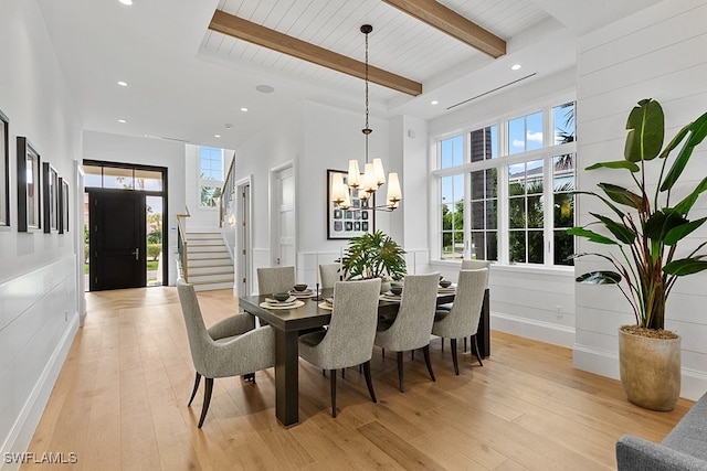 dining area featuring an inviting chandelier, light hardwood / wood-style floors, beam ceiling, and plenty of natural light