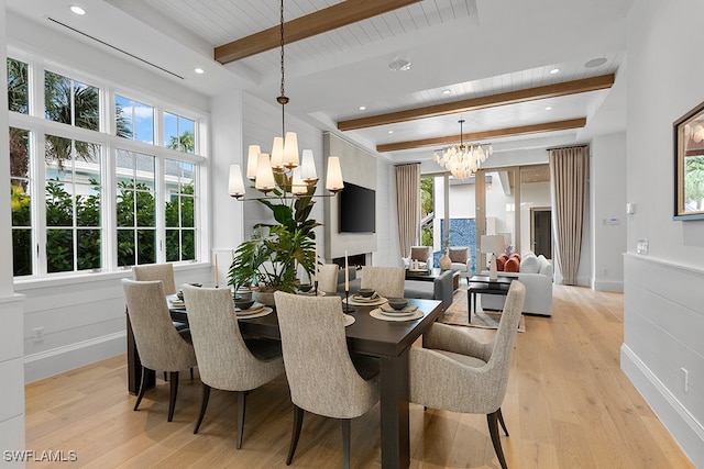 dining room with beamed ceiling, plenty of natural light, a chandelier, and light hardwood / wood-style flooring