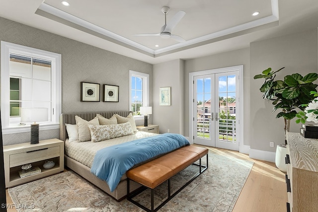 bedroom featuring ceiling fan, access to exterior, french doors, and a tray ceiling