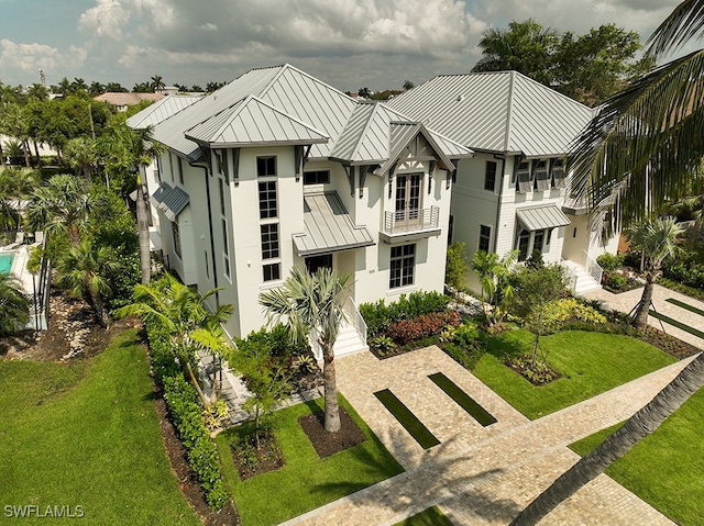 exterior space featuring a balcony and a front yard