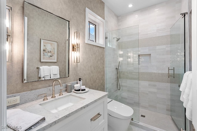 bathroom with vanity, toilet, and a shower with shower door