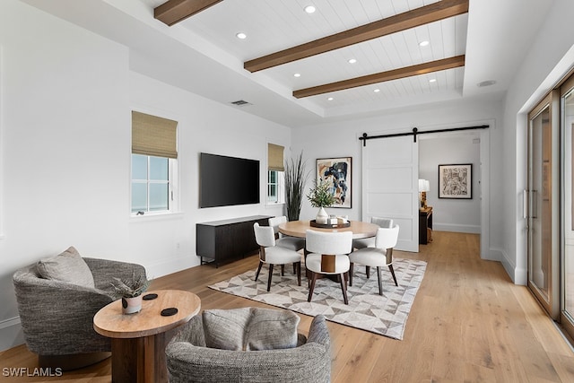 dining area with a barn door, light hardwood / wood-style floors, beamed ceiling, and wood ceiling