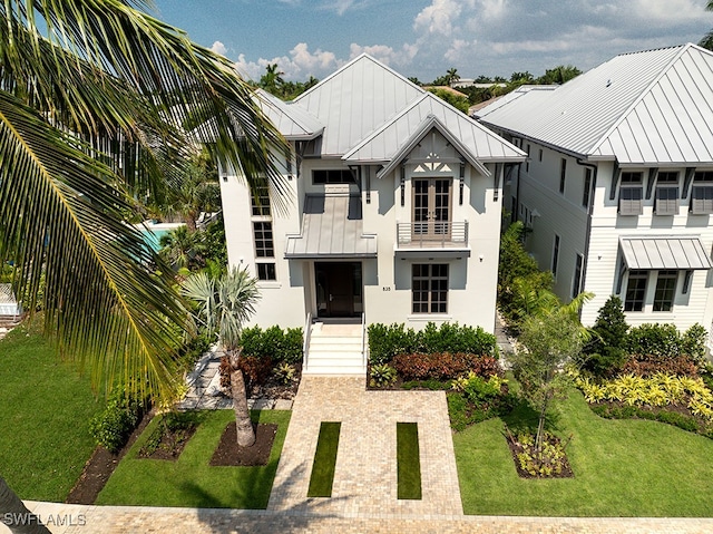 view of front facade featuring a balcony and a front yard