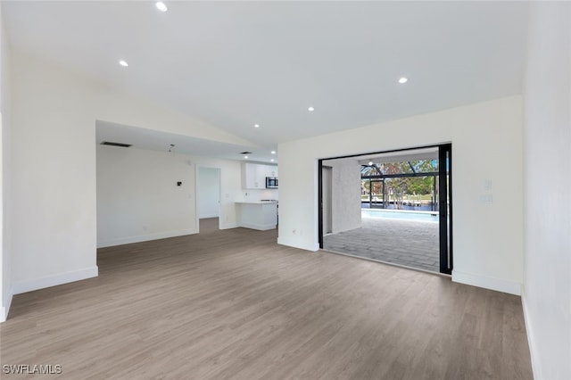 unfurnished living room featuring light wood-type flooring and lofted ceiling