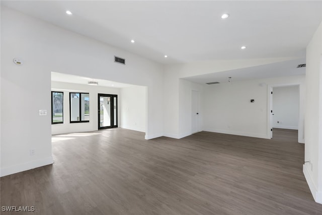 empty room with vaulted ceiling and dark hardwood / wood-style floors