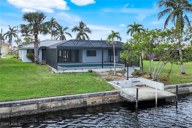 rear view of house featuring a water view, glass enclosure, and a lawn