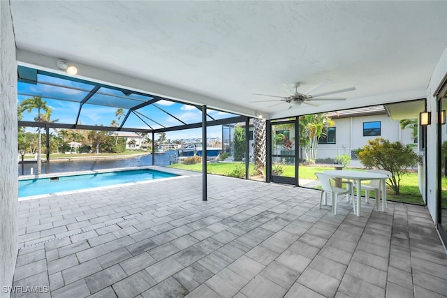 view of pool featuring a patio, a water view, a lanai, and ceiling fan