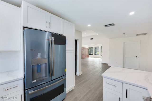 kitchen with stainless steel refrigerator with ice dispenser, white cabinetry, and light hardwood / wood-style floors