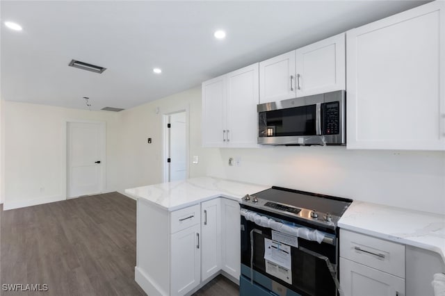 kitchen with kitchen peninsula, white cabinets, dark hardwood / wood-style floors, and stainless steel appliances