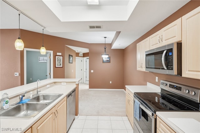 kitchen featuring light carpet, stainless steel appliances, hanging light fixtures, and sink