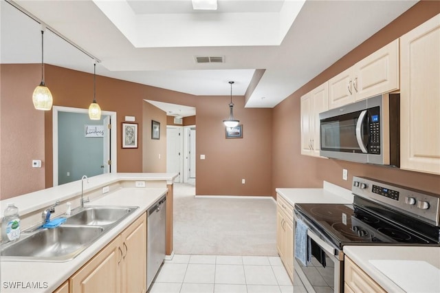 kitchen featuring a sink, visible vents, light countertops, appliances with stainless steel finishes, and hanging light fixtures