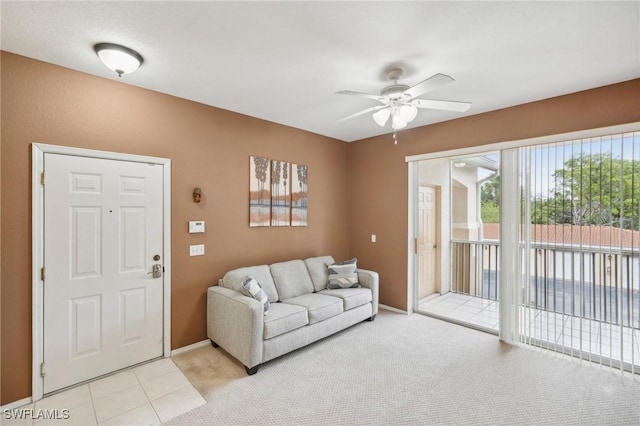 carpeted living area featuring baseboards and a ceiling fan