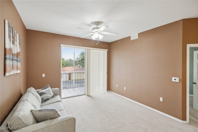 living area featuring baseboards, carpet, visible vents, and a ceiling fan