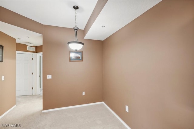 spare room featuring visible vents, baseboards, and light colored carpet