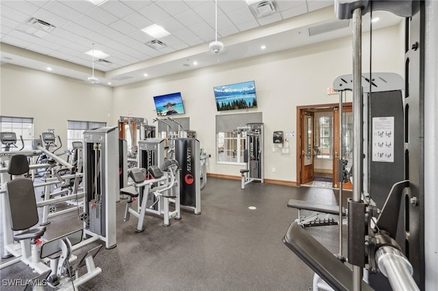 gym featuring a drop ceiling and a towering ceiling