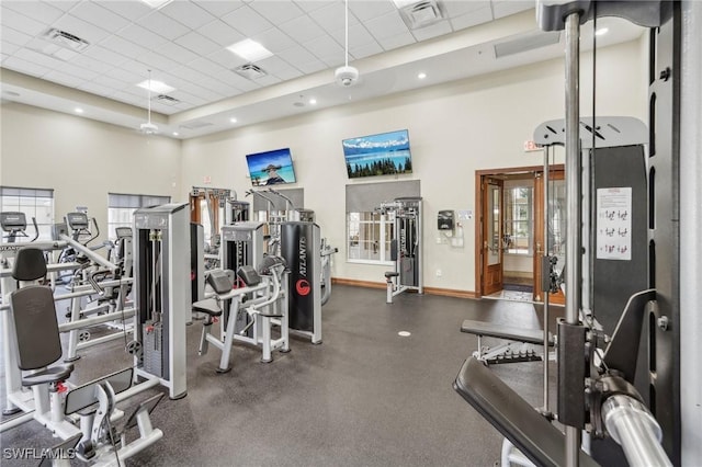 gym featuring a paneled ceiling, visible vents, and baseboards