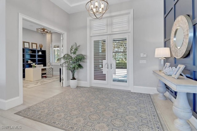 foyer with french doors and a notable chandelier