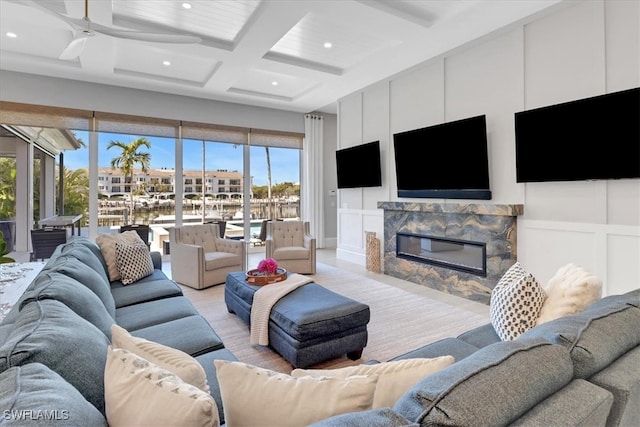 living room featuring ceiling fan, plenty of natural light, beamed ceiling, and coffered ceiling