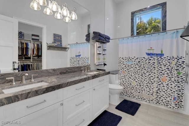 bathroom featuring curtained shower, vanity, and toilet