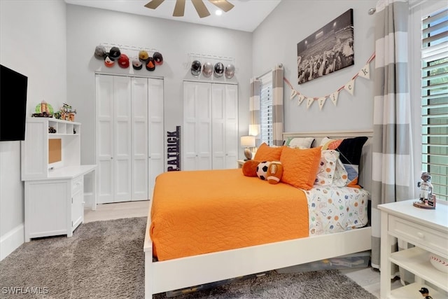 bedroom featuring multiple closets, ceiling fan, and light hardwood / wood-style flooring