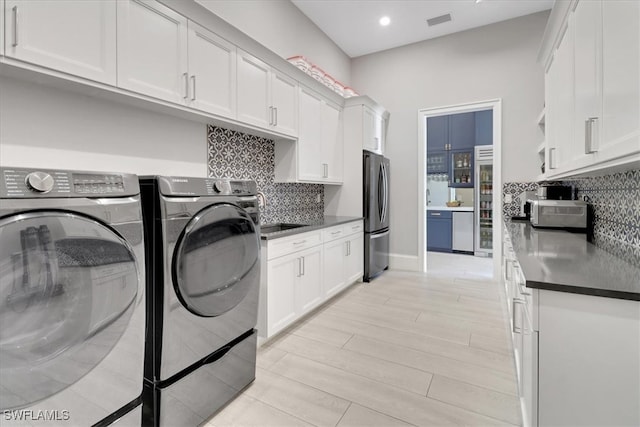 washroom featuring sink, light hardwood / wood-style flooring, and washing machine and clothes dryer