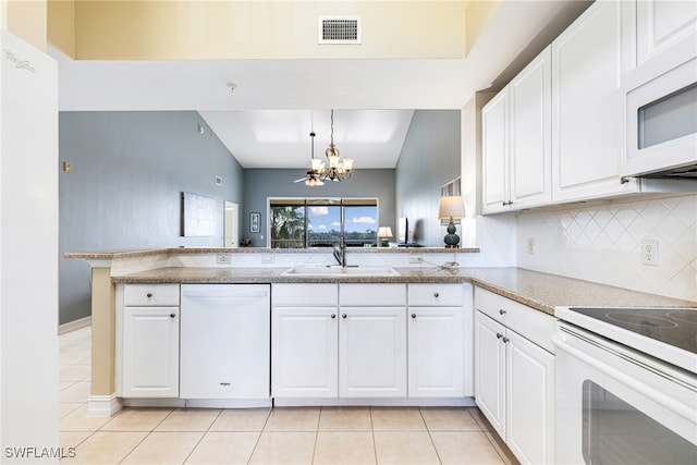 kitchen featuring white appliances, sink, white cabinetry, kitchen peninsula, and a chandelier