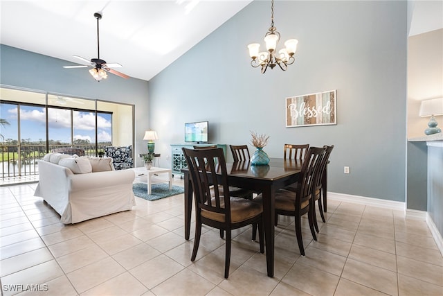 dining space featuring ceiling fan with notable chandelier, high vaulted ceiling, and light tile patterned floors