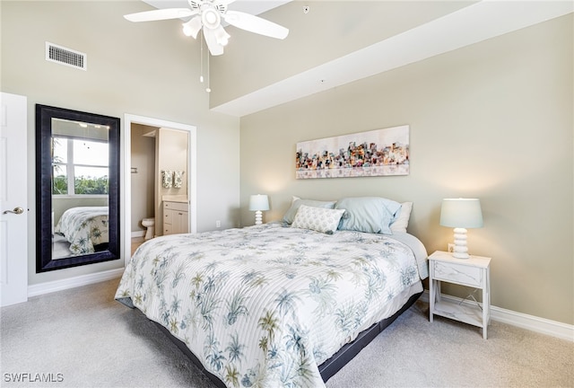 carpeted bedroom with ceiling fan, ensuite bathroom, and a high ceiling