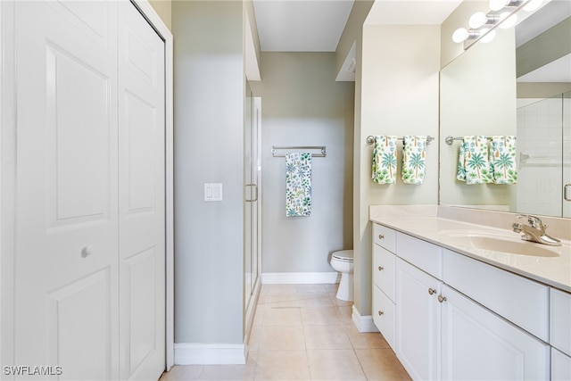 bathroom with tile patterned floors, vanity, an enclosed shower, and toilet