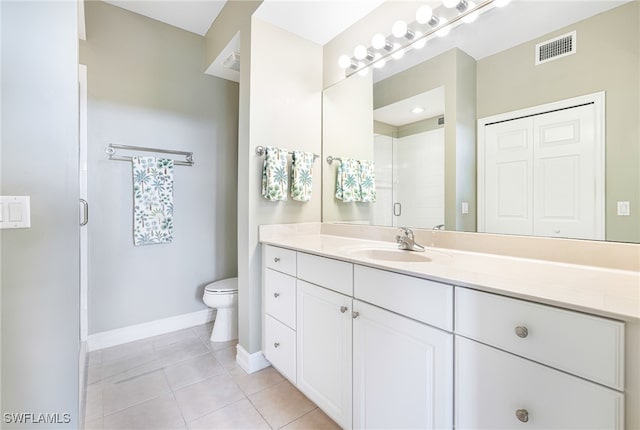 bathroom featuring tile patterned flooring, vanity, toilet, and walk in shower