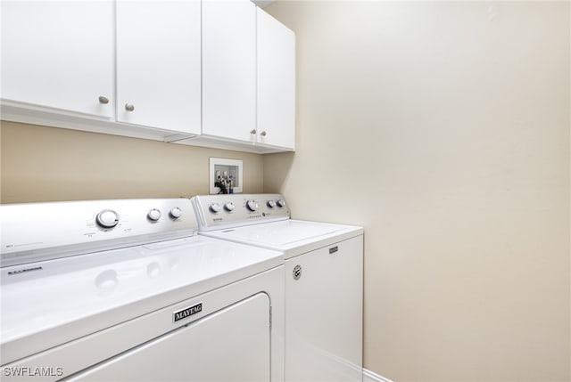 washroom featuring washer and clothes dryer and cabinets