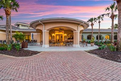 back house at dusk featuring a patio and ceiling fan