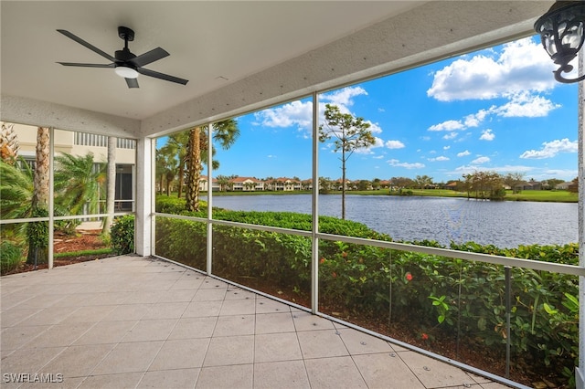 unfurnished sunroom with ceiling fan and a water view